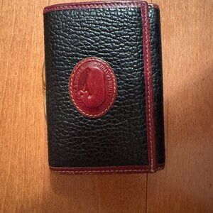 Dooney and Bourke trifold wallet in black pebble leather with cognac brown trim